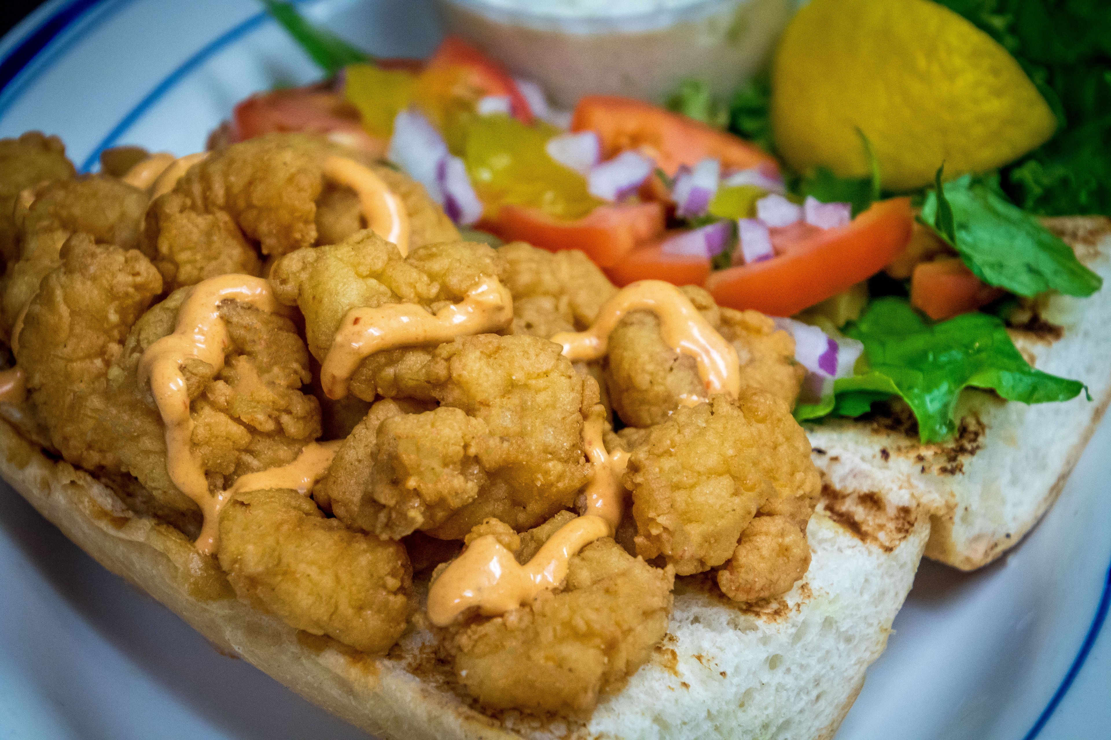Shrimp po'boy sandwich with remoulade sauce, tomato, and onion