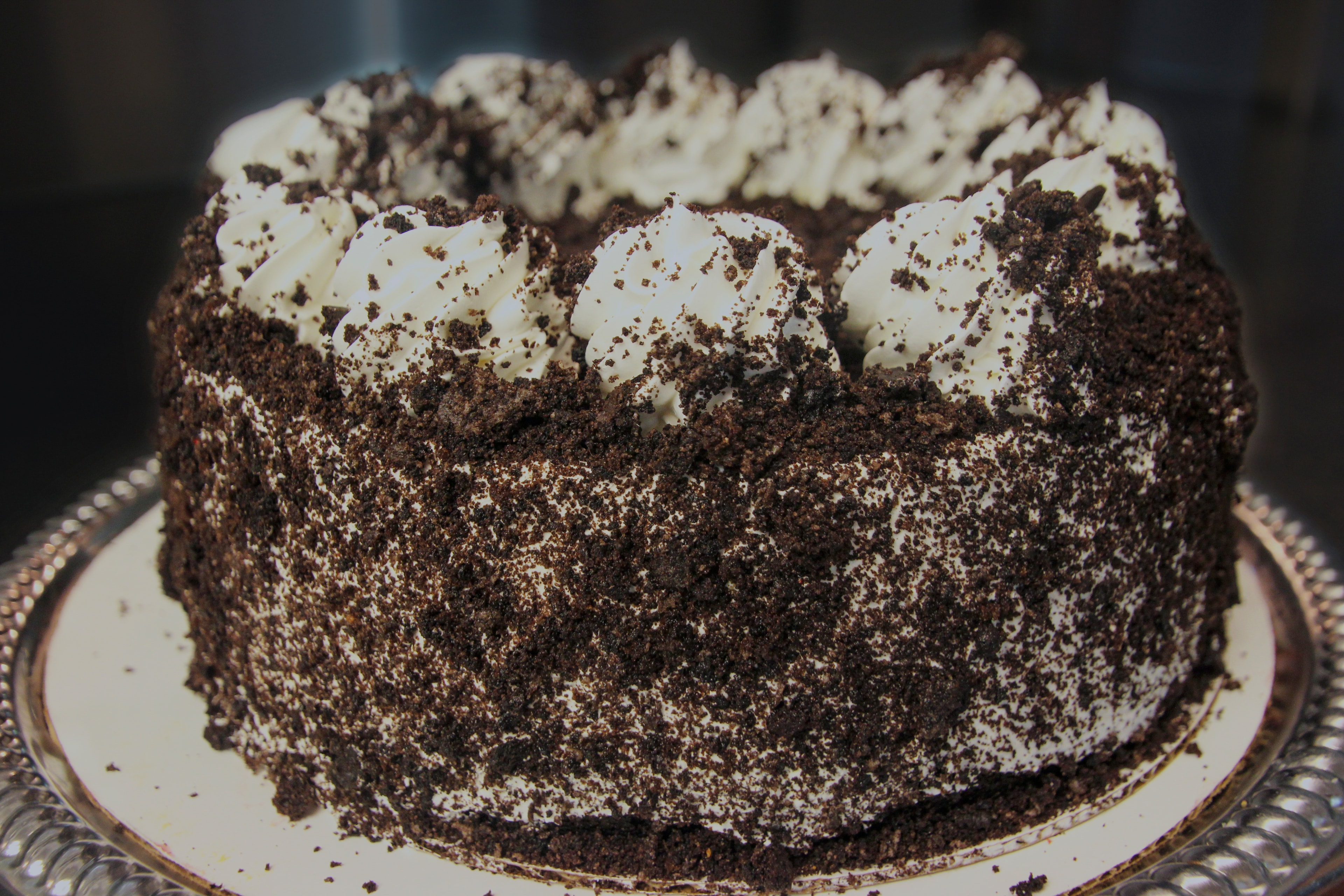 Oreo cheesecake covered in cookie crumbles with whipped cream topping